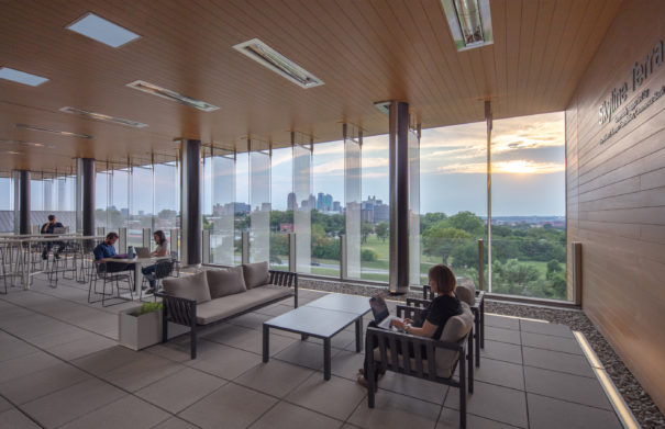 Upper level of the building interior. Shows students studying in a casual social/study space that looks out over the Kansas City skyline.